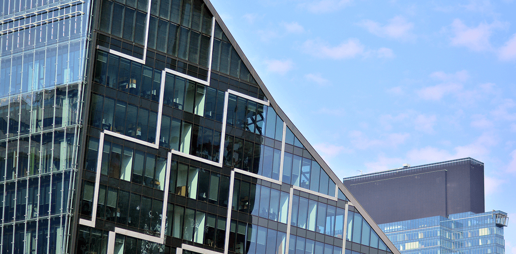 Bâtiment en verre incliné avec un motif abstrait sur sa façade